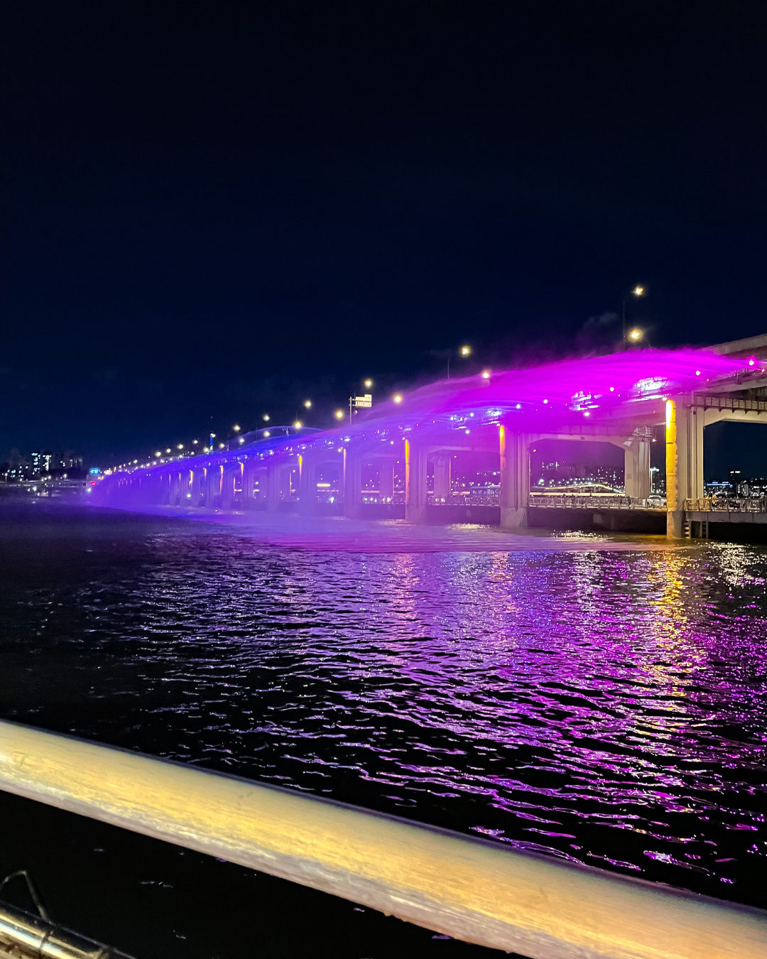 Banpo Bridge rainbow fountain show lit up in purple at night reflecting on the Han River Seoul Korea BTS ARMY