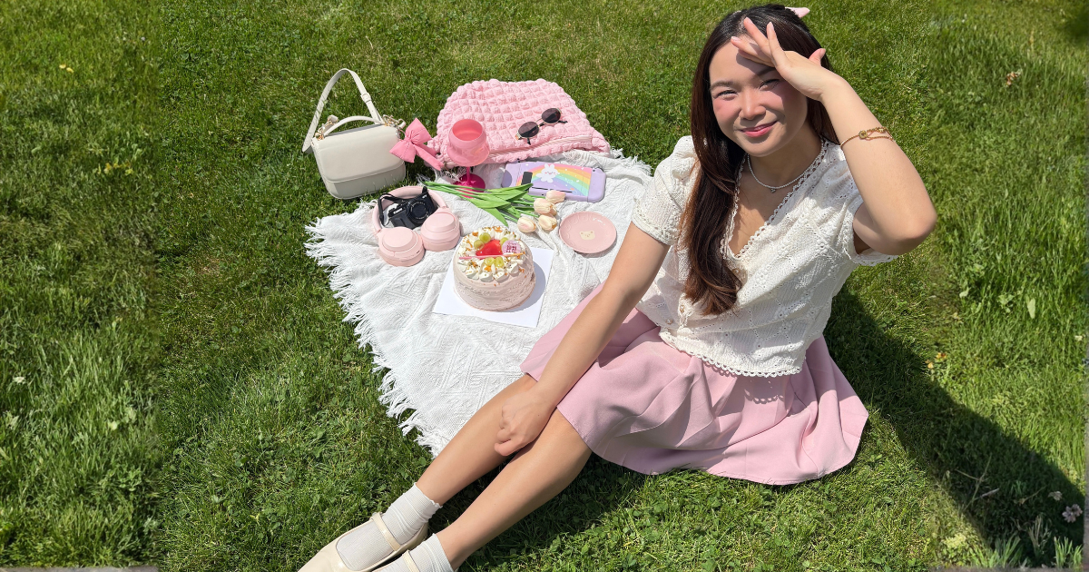 Roxanne Lacap Toronto lifestyle creator sitting on a white blanket at a cute spring picnic with a strawberry cake pink accessories and tulips whimsy spring activities