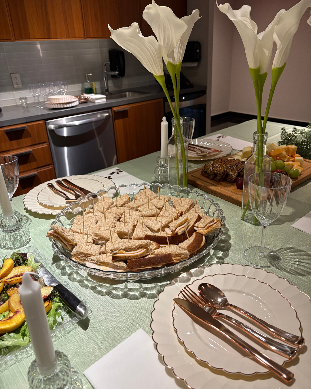 spring dinner party table with finger sandwiches cheese board calla lilies rose gold cutlery and scalloped plates whimsy spring activities